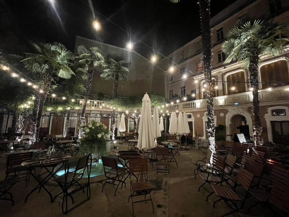 Cour intérieure à palmiers et guirlandes lumineuses