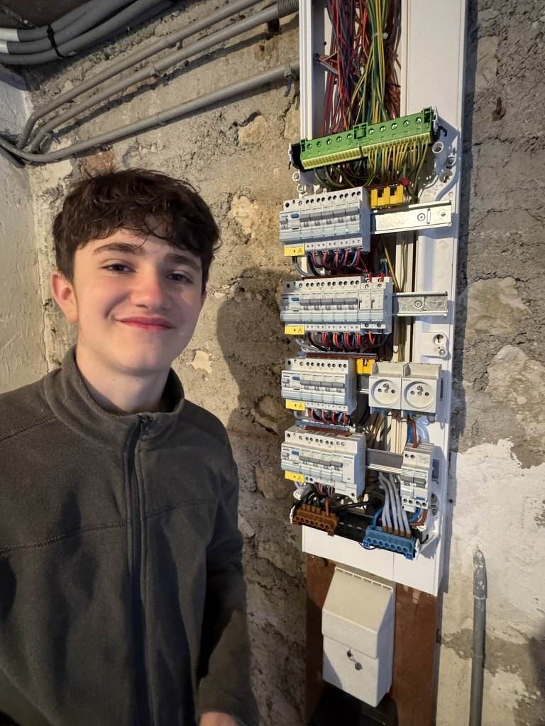 Le fils de Frédéric Pfeiffer devant le tableau électrique qu’il a réalisé